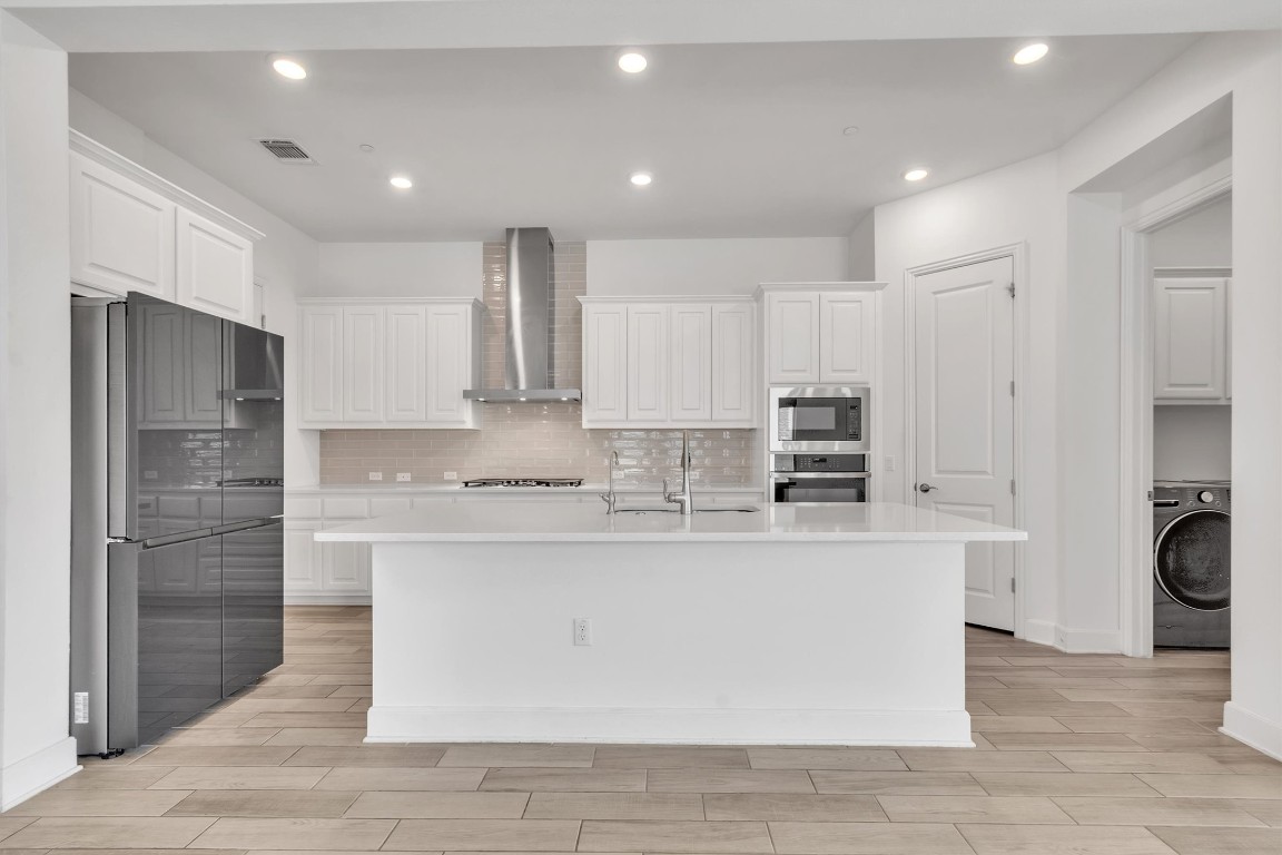 12110 Moriah Bend Austin, TX 78732 - Photo 11 of 40 a large kitchen with stainless steel appliances granite countertop a stove and a refrigerator