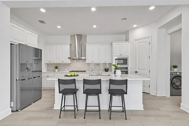 a kitchen with white cabinets and stainless steel appliances