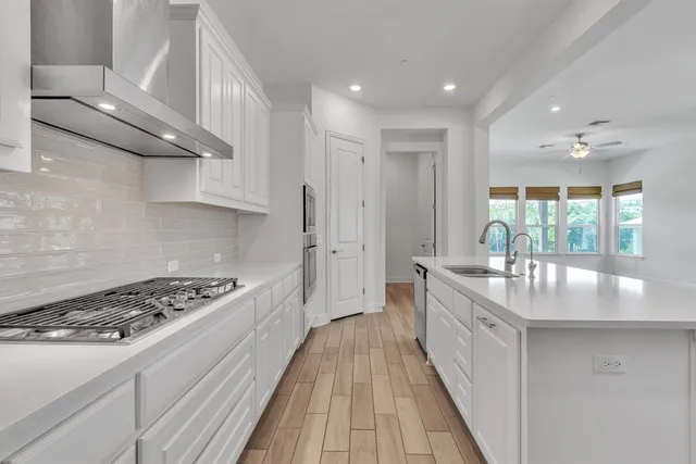 a kitchen with stainless steel appliances granite countertop a lot of counter space and wooden floors