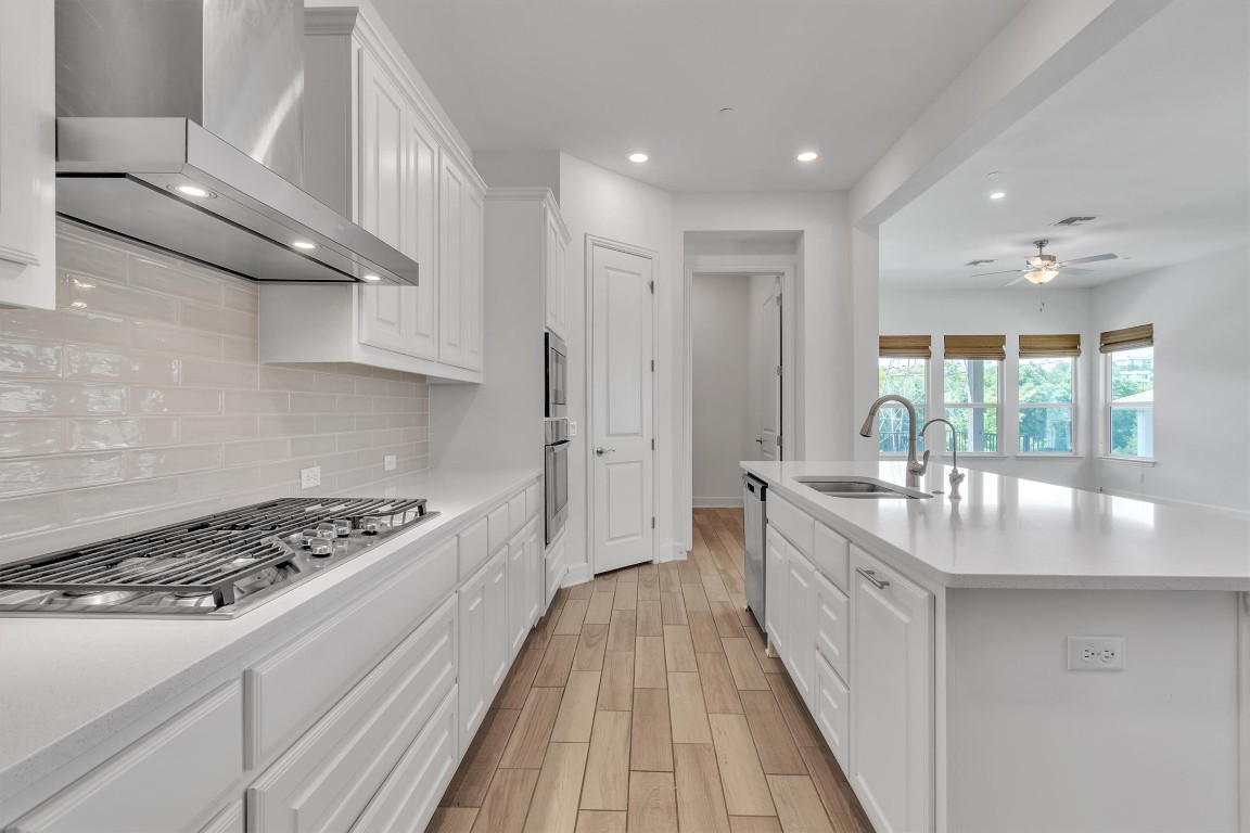 12110 Moriah Bend Austin, TX 78732 - Photo 13 of 40 a kitchen with stainless steel appliances granite countertop a lot of counter space and wooden floors