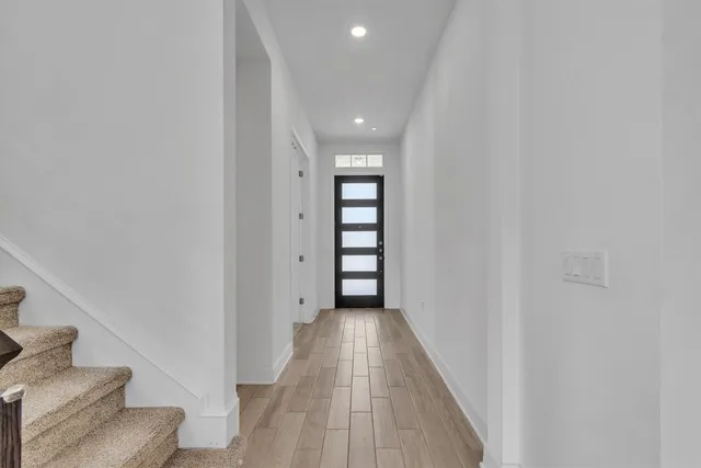 a view of a hallway with wooden floor and staircase