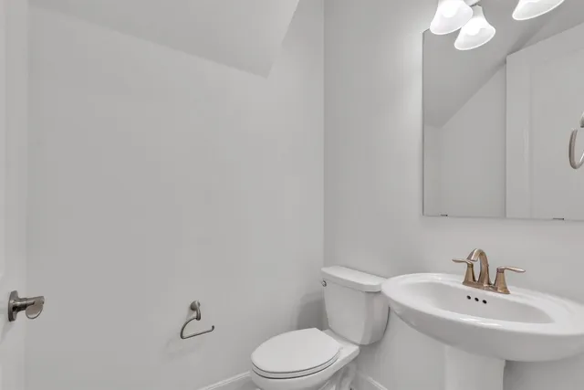 a bathroom with a sink a toilet and mirror