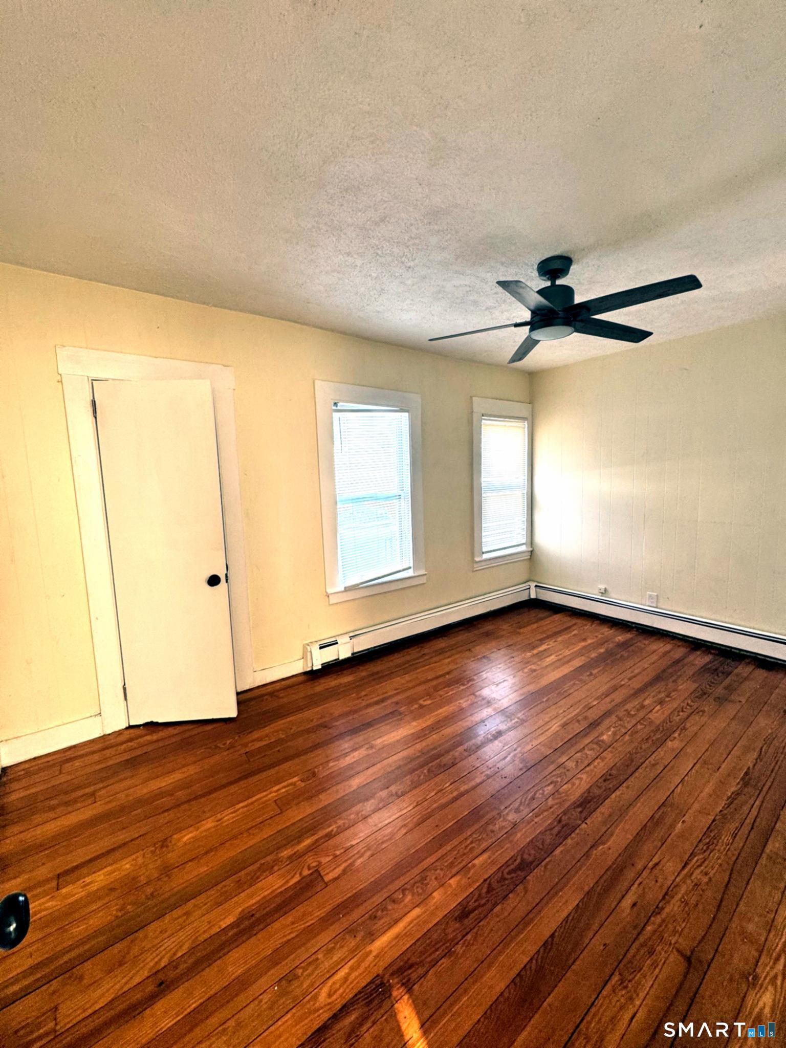 175 Wilson Street, Unit 179 Bridgeport, CT 06605 - Photo 6 of 9 wooden floor in an empty room with a window