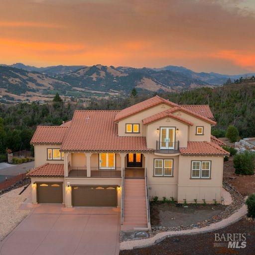 a front view of a house with a yard and mountain view