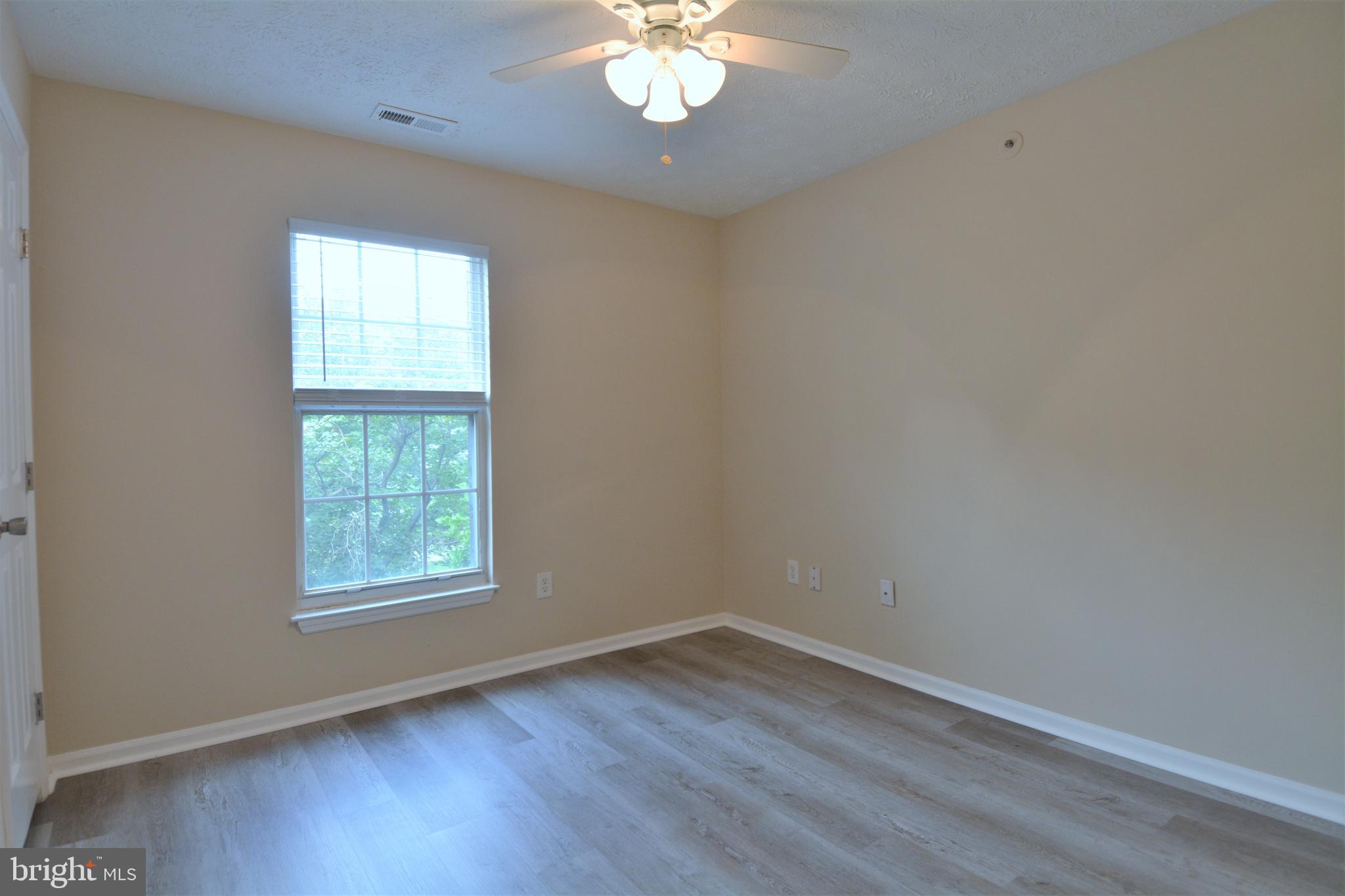 1307 J Clover Valley Way, Unit 1307J Edgewood, MD 21040 - Photo 11 of 25 an empty room with wooden floor and windows