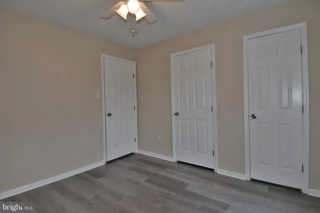 a view of wooden floor and a chandelier fan in a room