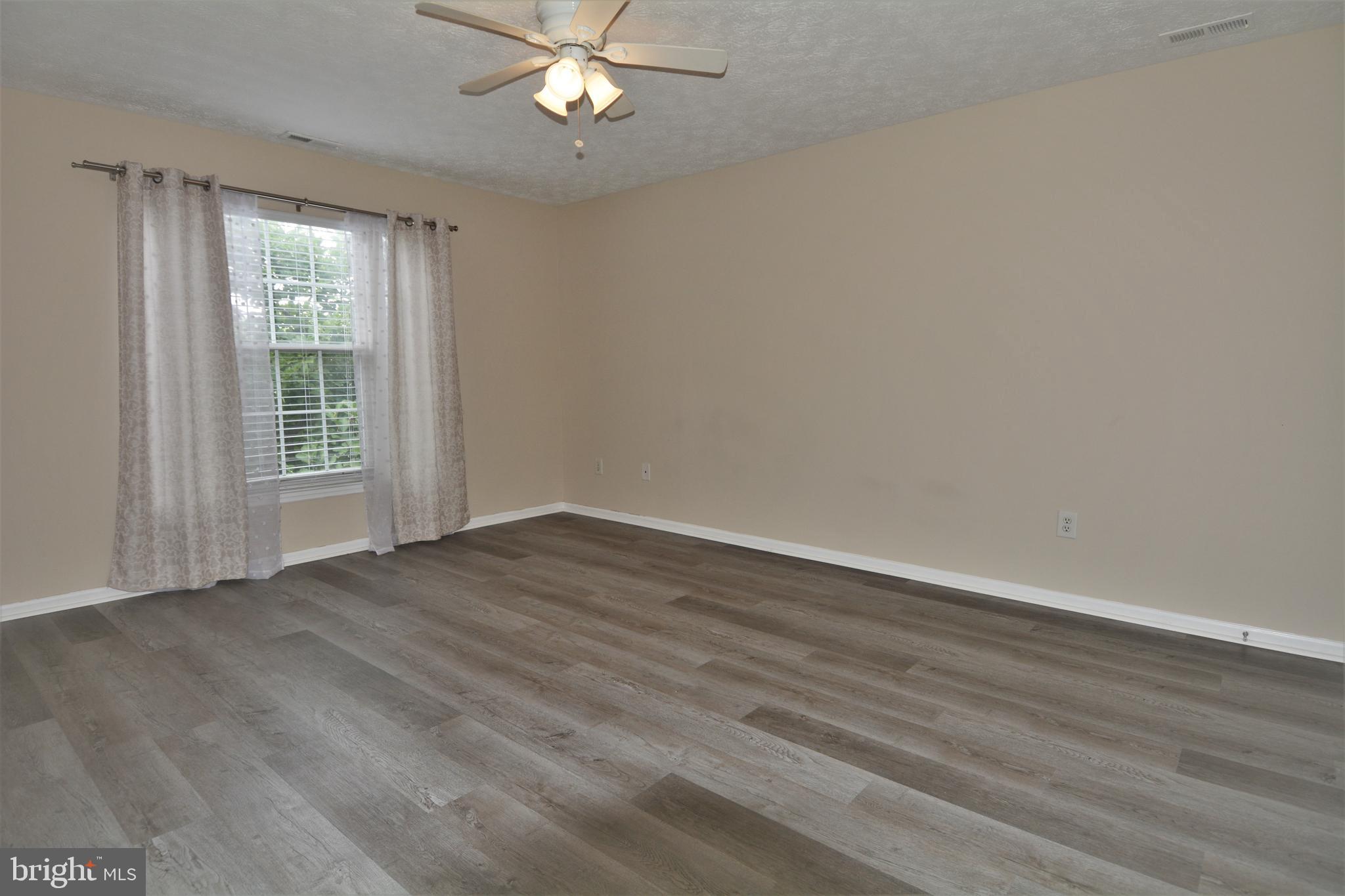1307 J Clover Valley Way, Unit 1307J Edgewood, MD 21040 - Photo 15 of 25 a view of an empty room with wooden floor and a window