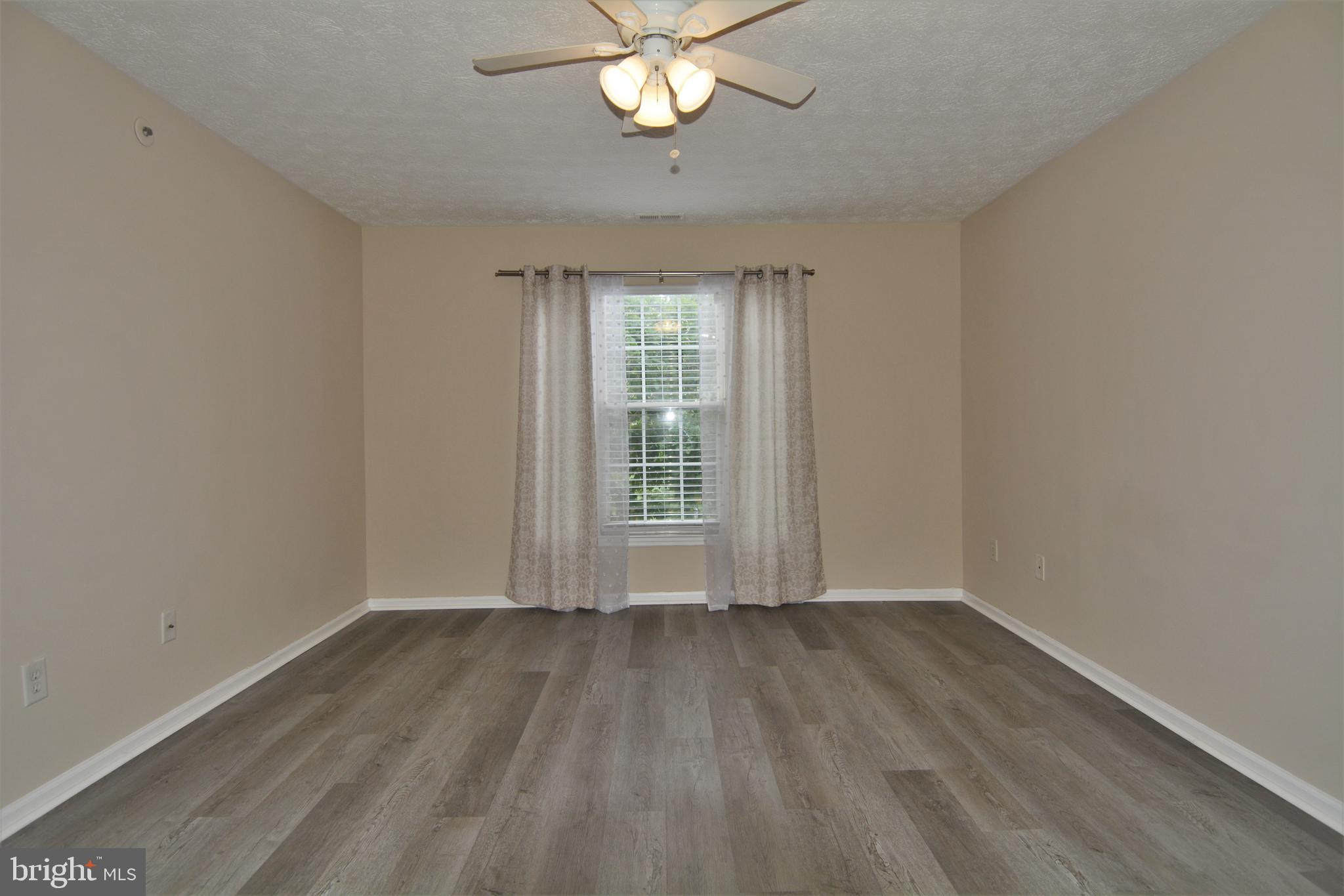 1307 J Clover Valley Way, Unit 1307J Edgewood, MD 21040 - Photo 16 of 25 a view of wooden floor and a chandelier fan in a room