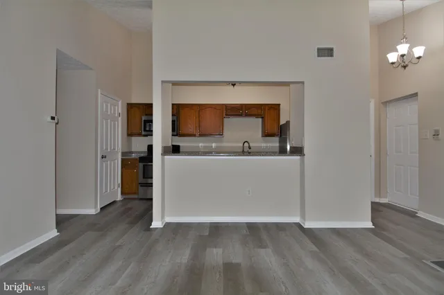 a view of a kitchen with a sink stove cabinets and empty room