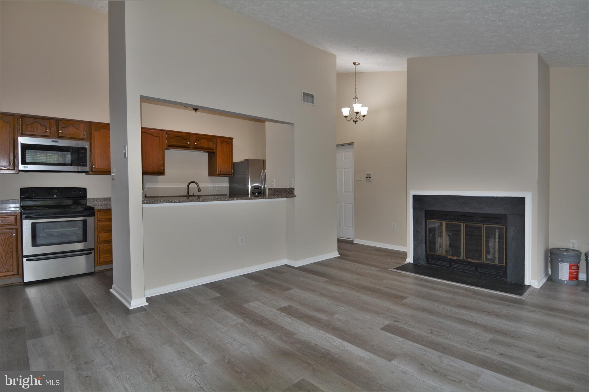 1307 J Clover Valley Way, Unit 1307J Edgewood, MD 21040 - Photo 6 of 25 a view of a kitchen with a sink stove cabinets and empty room
