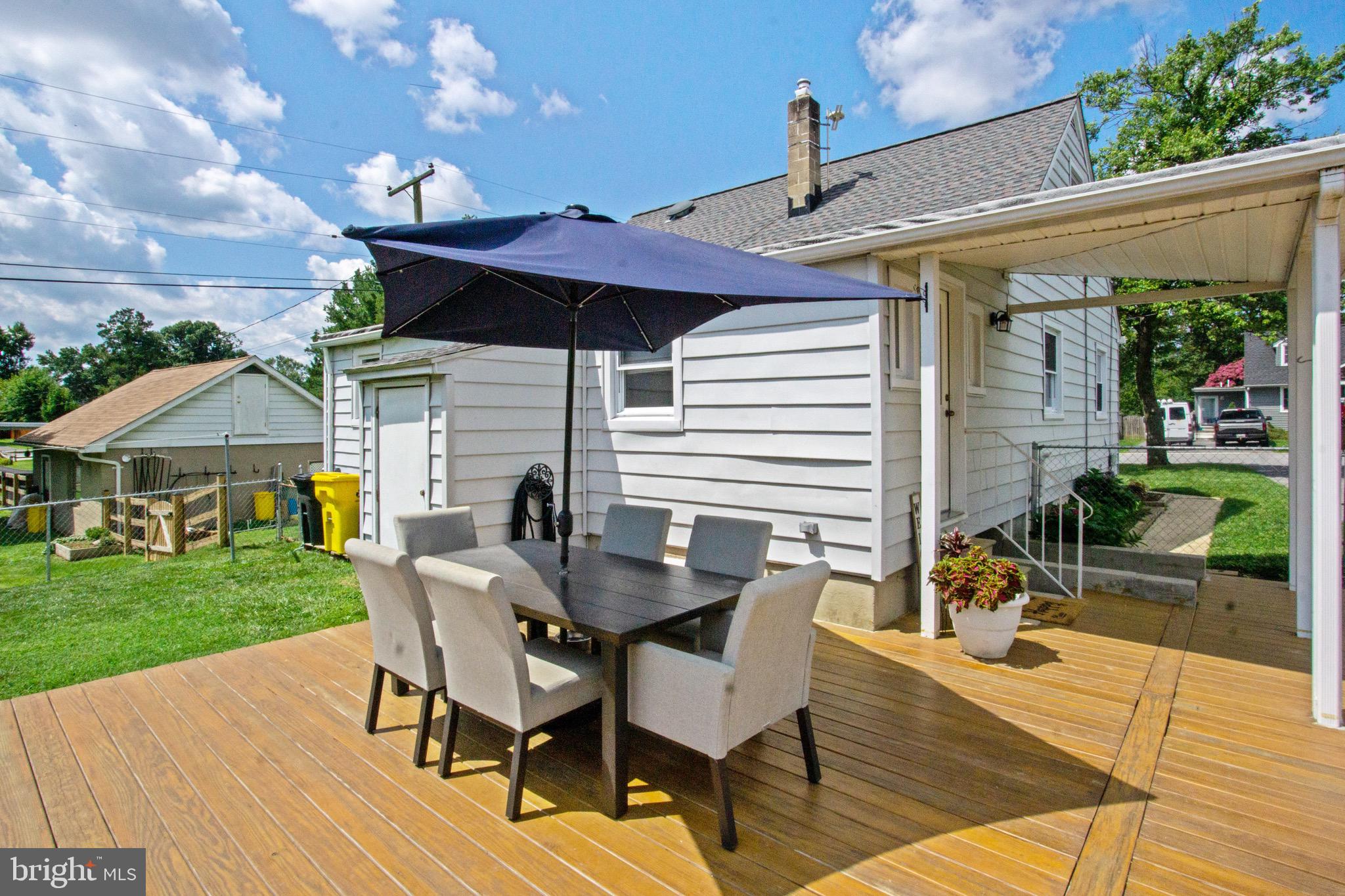 205 South Longcross Road Linthicum Heights, MD 21090 - Photo 55 of 57 a view of a patio with table and chairs potted plants with wooden floor and fence