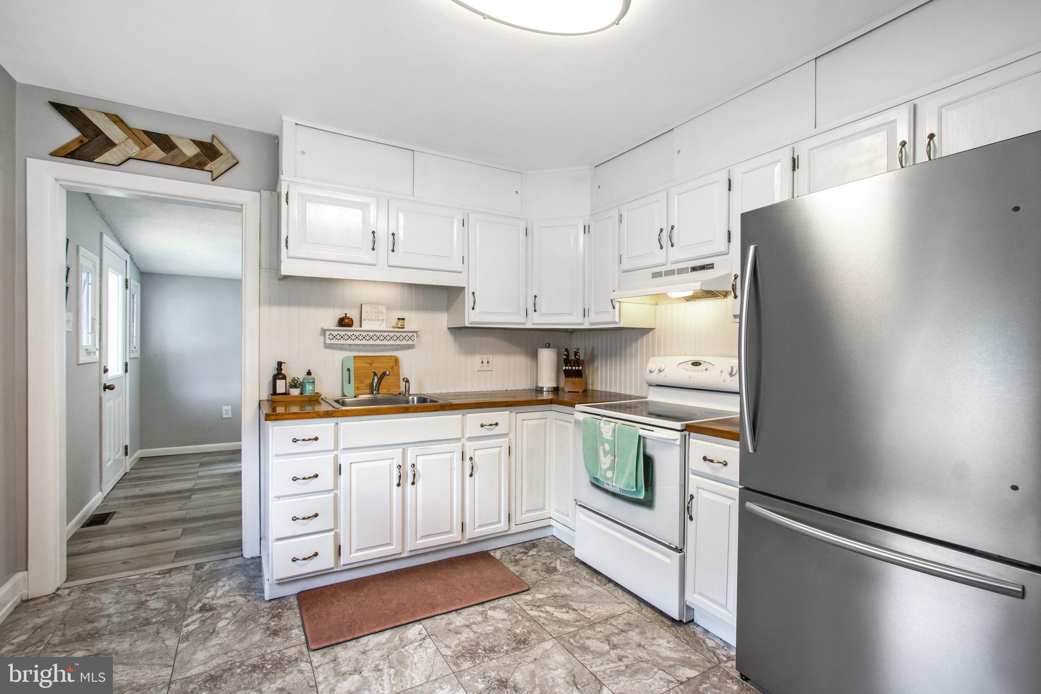 205 South Longcross Road Linthicum Heights, MD 21090 - Photo 10 of 57 a kitchen with stainless steel appliances white cabinets and wooden floors