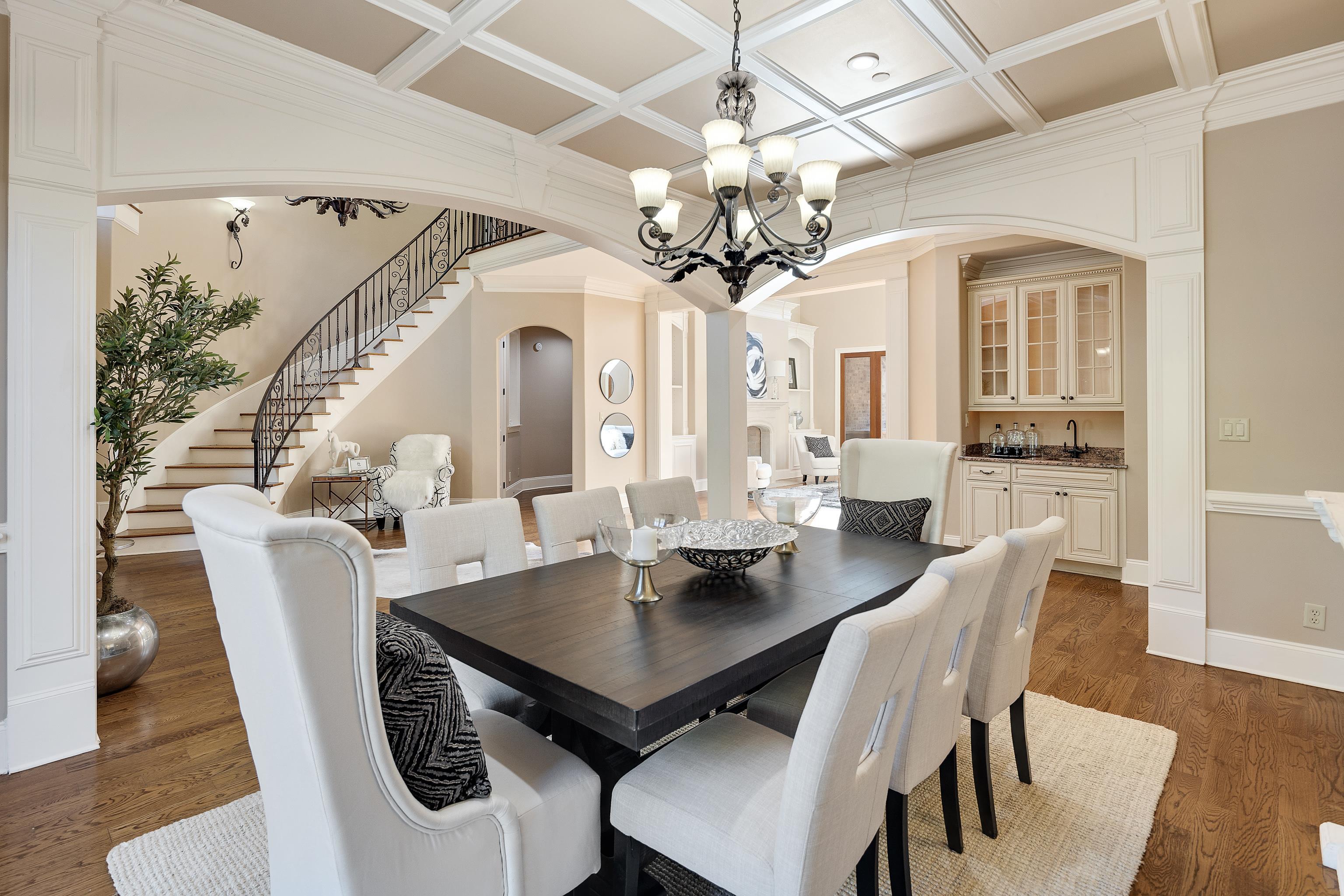 425 Buckland Cove Eads, TN 38028 - Photo 7 of 29 Dining area with stairs, crown molding, arched walkways, dark wood finished floors, and a chandelier
