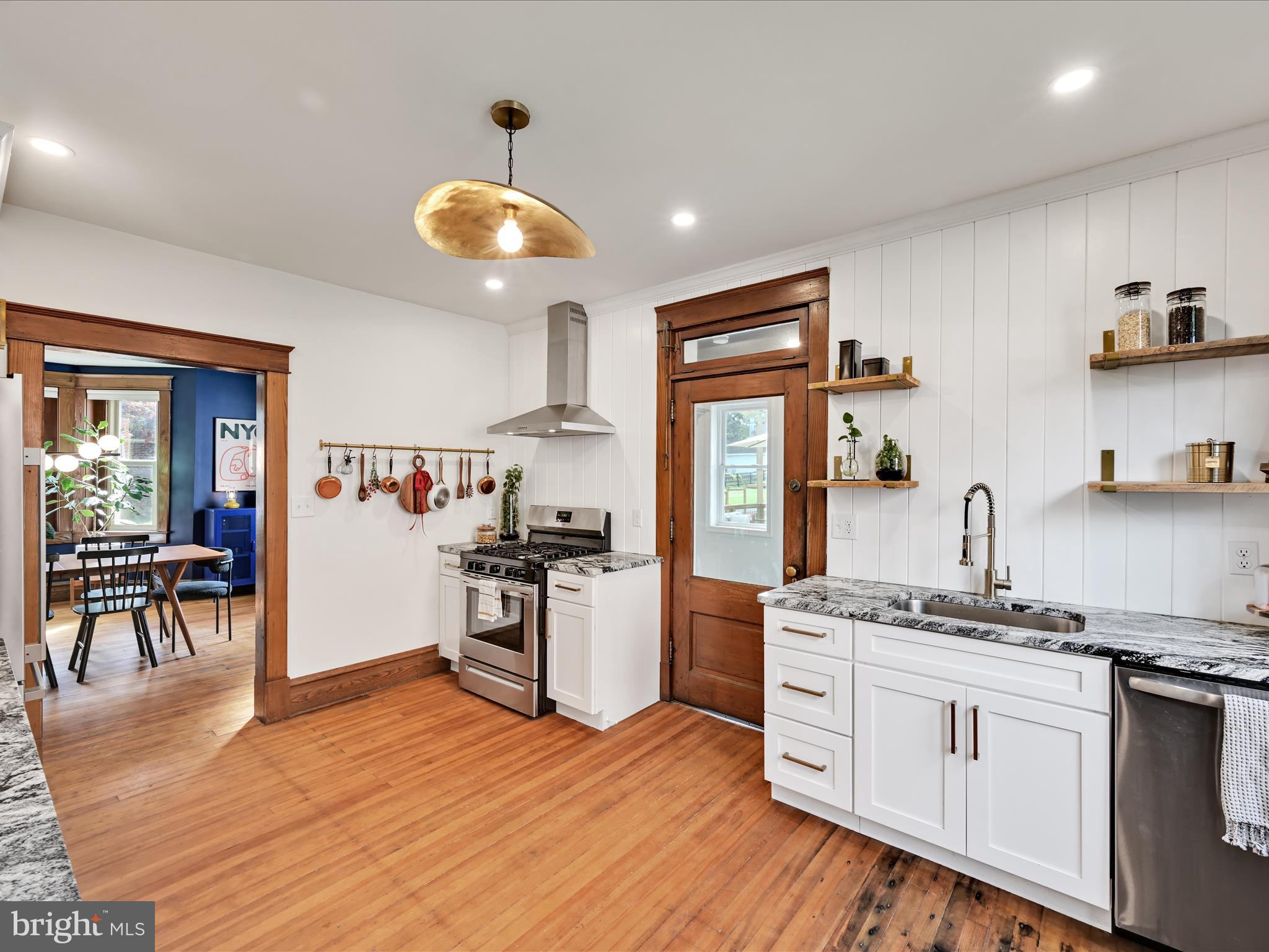 28 Charles Road Lancaster, PA 17603 - Photo 11 of 45 a kitchen with stainless steel appliances granite countertop a stove top oven a sink dishwasher and white cabinets with wooden floor