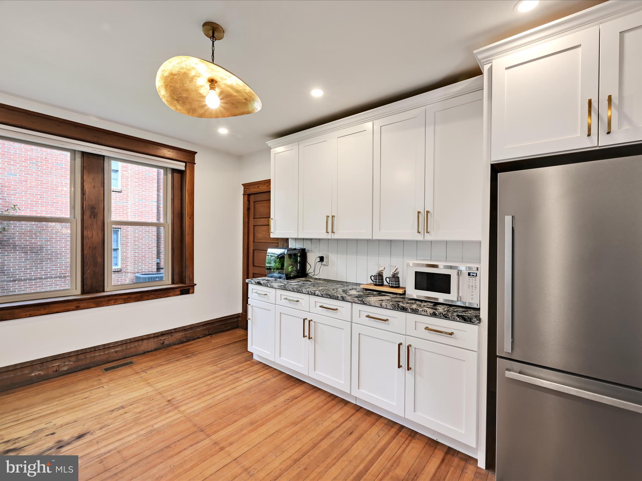 28 Charles Road Lancaster, PA 17603 - Photo 13 of 45 a kitchen with stainless steel appliances granite countertop a refrigerator a stove and white cabinets with wooden floor