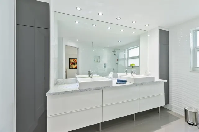 a bathroom with a double vanity sink toilet and shower