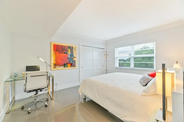 a bed sitting in a bedroom next to a window