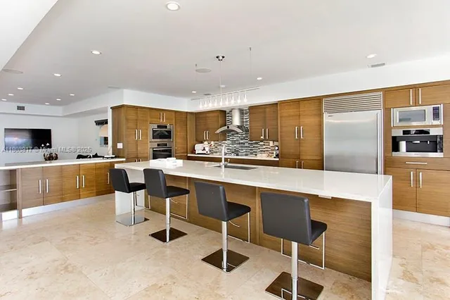 a kitchen with stainless steel appliances kitchen island granite countertop a sink and cabinets