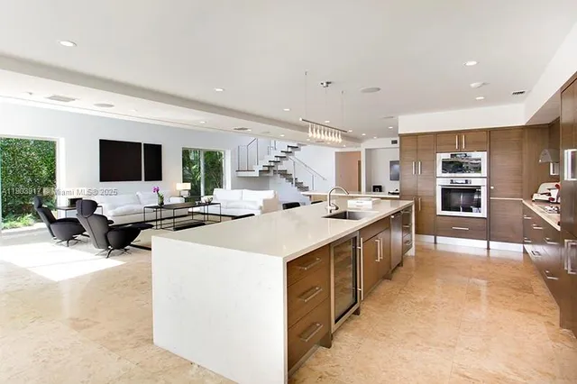 a large white kitchen with a large window and stainless steel appliances