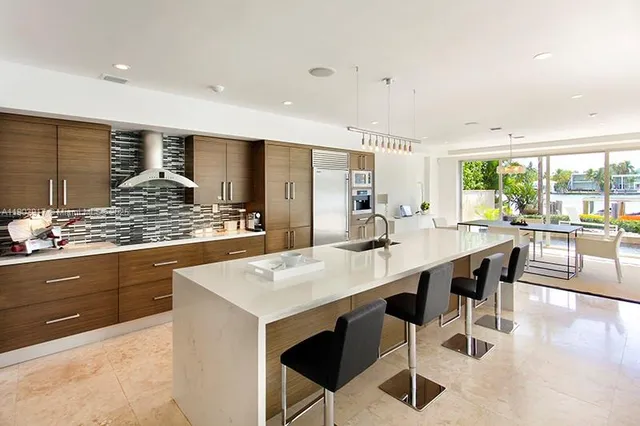 a kitchen with stainless steel appliances kitchen island granite countertop a table chairs sink and cabinets