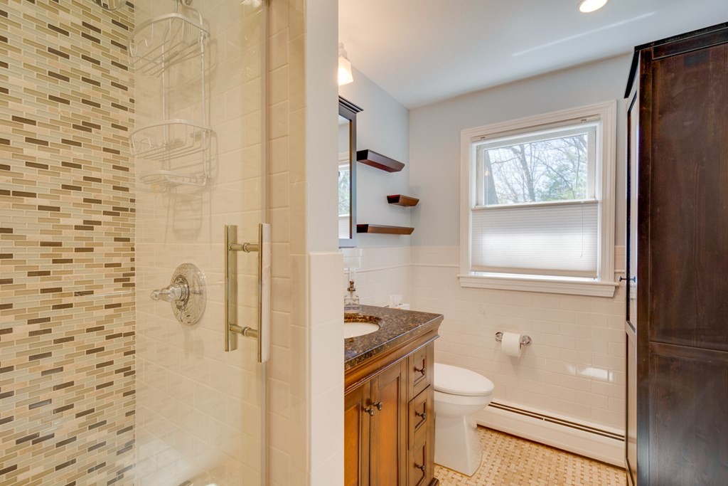 14 Highgate Street Needham, MA 02492 - Photo 18 of 27 a bathroom with a granite countertop toilet a sink and a shower