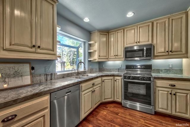 a kitchen with granite countertop a stove sink and cabinets