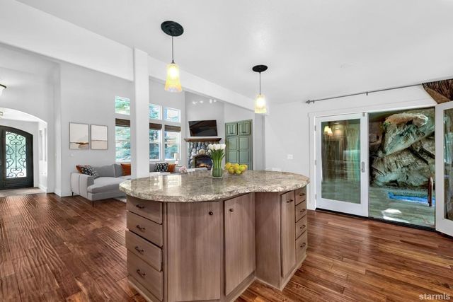 a kitchen with stainless steel appliances granite countertop a kitchen island a stove and a sink