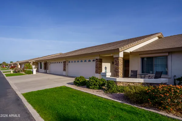 a front view of a house with a yard outdoor seating and garage