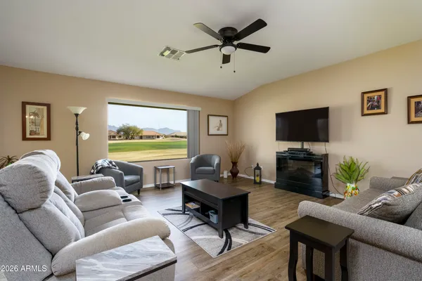 a living room with furniture a flat screen tv and a large window