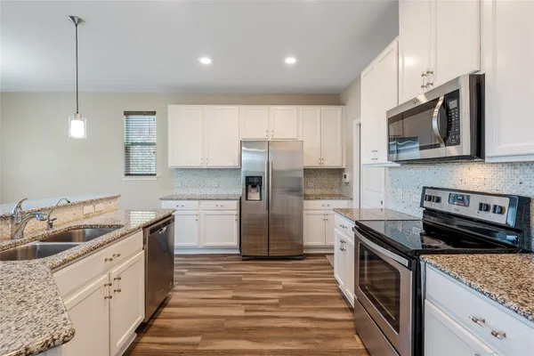 a kitchen with stainless steel appliances granite countertop a sink stove and refrigerator