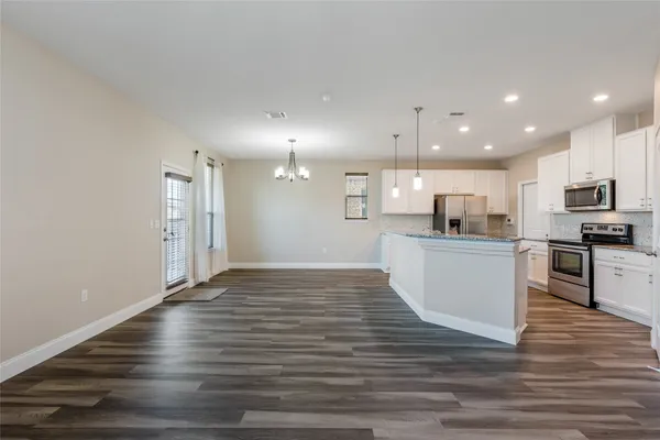 a view of kitchen with granite countertop stainless steel appliances refrigerator oven stove microwave and cabinets