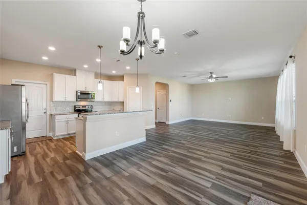 a view of a kitchen with a refrigerator and a stove top oven