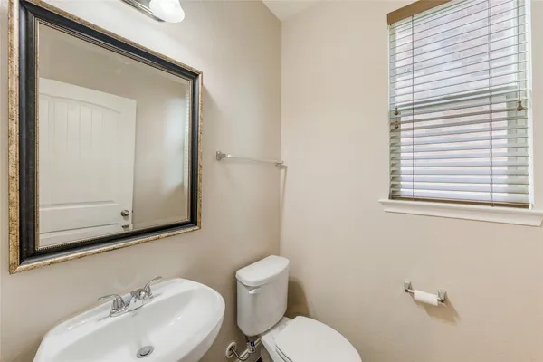 a bathroom with a toilet a sink and a mirror