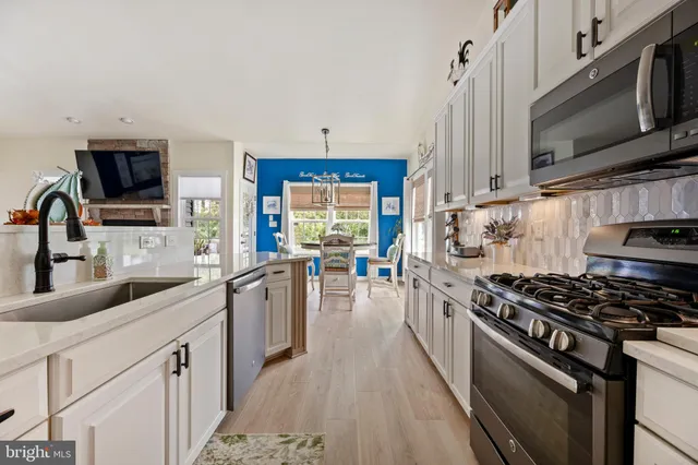 a kitchen with stainless steel appliances a sink a stove and a microwave