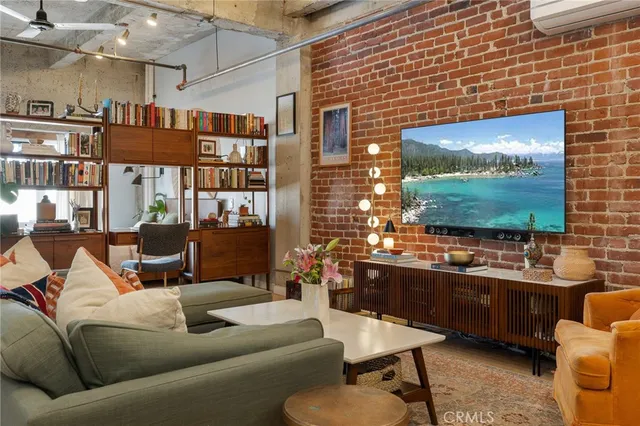 a living room with furniture a flat screen tv and a wall painting