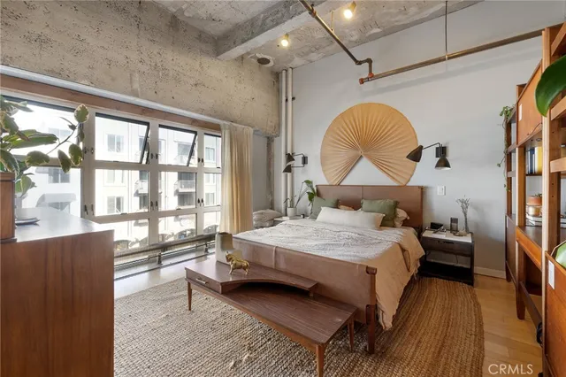 a bedroom with a bed next to a window