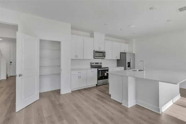 a kitchen with white cabinets and stainless steel appliances