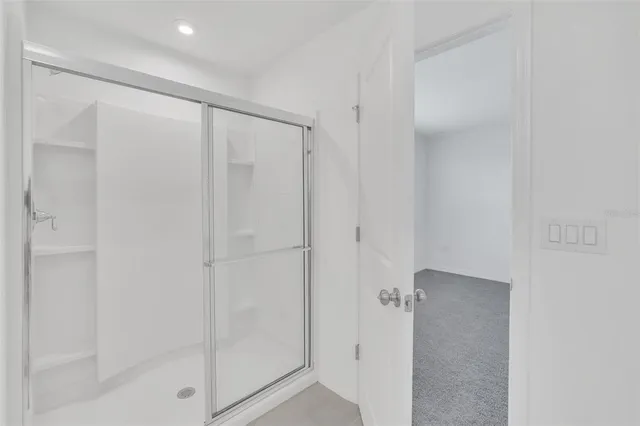 a bathroom with a shower and a glass door
