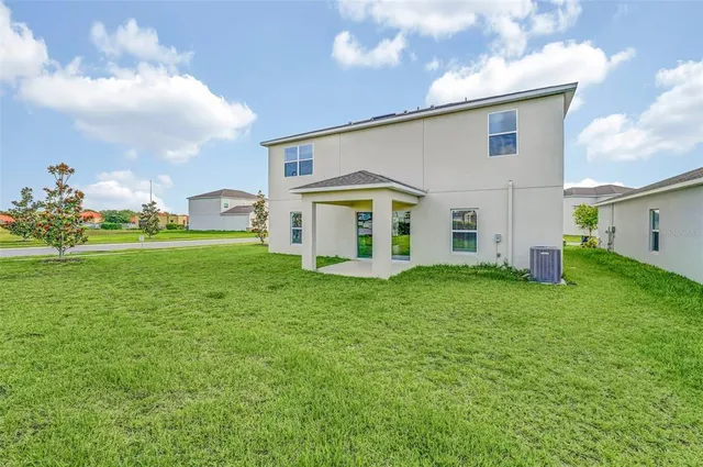 a front view of a house with garden and trees