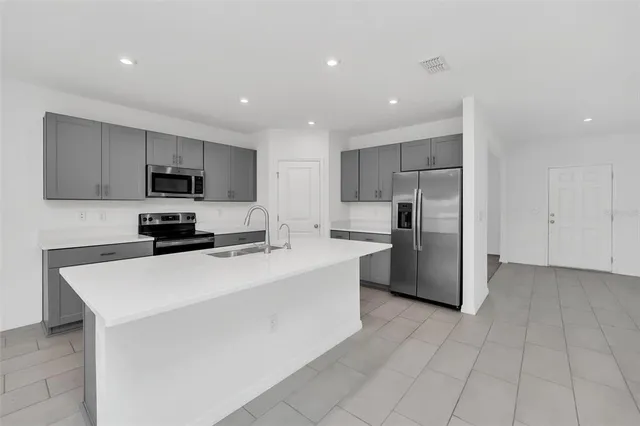 a kitchen with stainless steel appliances a refrigerator sink and microwave