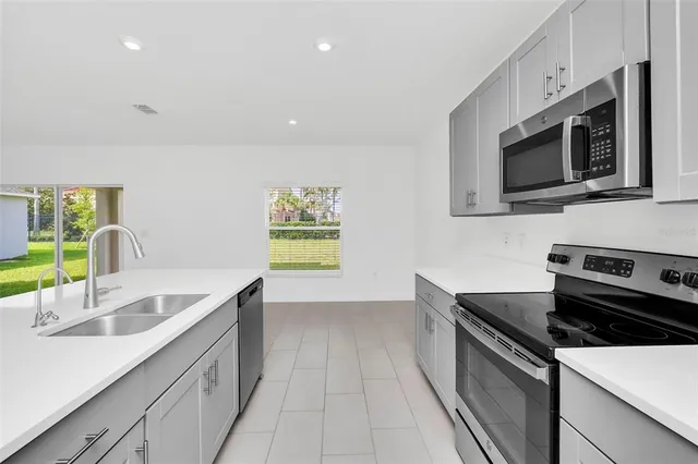 a kitchen with stainless steel appliances a sink microwave and stove