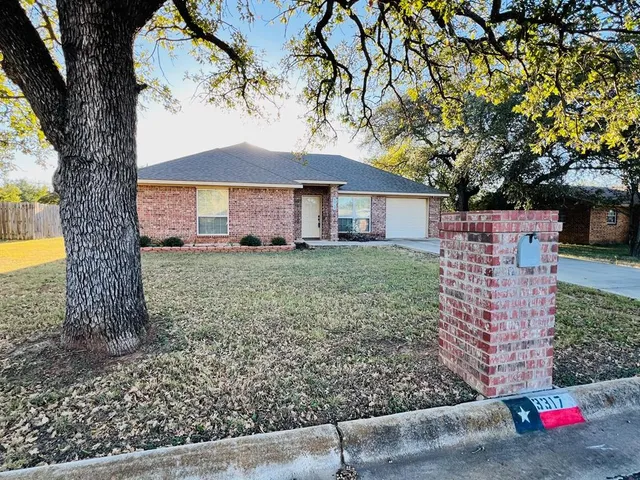 a view of a house with a tree in the yard
