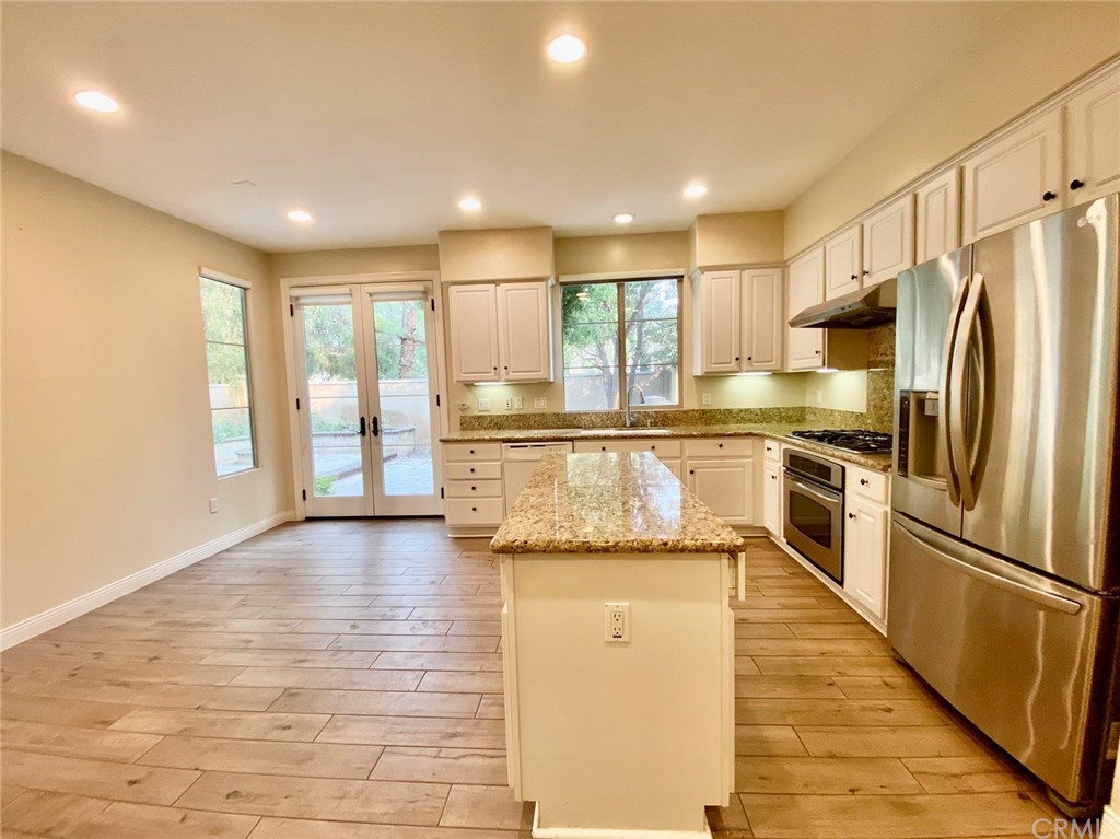 181 Rhapsody Irvine, CA 92620 - Photo 21 of 73 a kitchen with stainless steel appliances granite countertop a refrigerator a sink and a stove