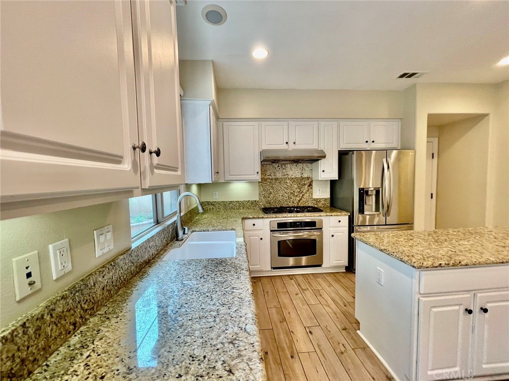181 Rhapsody Irvine, CA 92620 - Photo 27 of 73 a large kitchen with stainless steel appliances granite countertop a stove a sink and a refrigerator