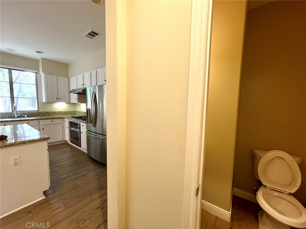 181 Rhapsody Irvine, CA 92620 - Photo 31 of 73 a kitchen with a refrigerator a sink and wooden floor