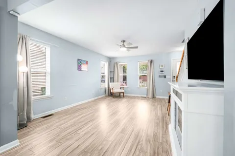 a view of a living room with hardwood floor and a flat screen tv