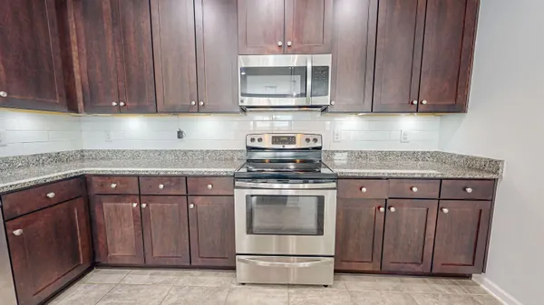 a kitchen with granite countertop wooden cabinets a sink and dishwasher
