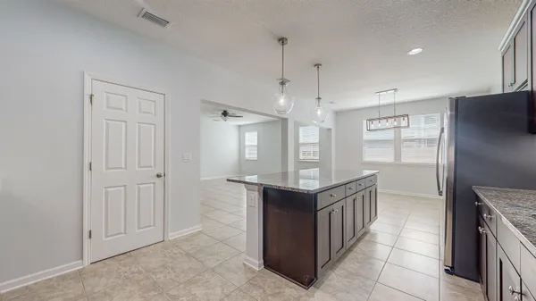 a kitchen with kitchen island granite countertop a sink cabinets and window