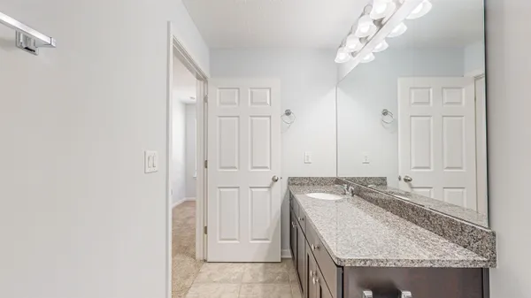 an empty room with a chandelier fan and windows