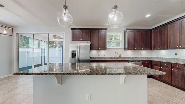 a kitchen with stainless steel appliances granite countertop a sink stove microwave and refrigerator